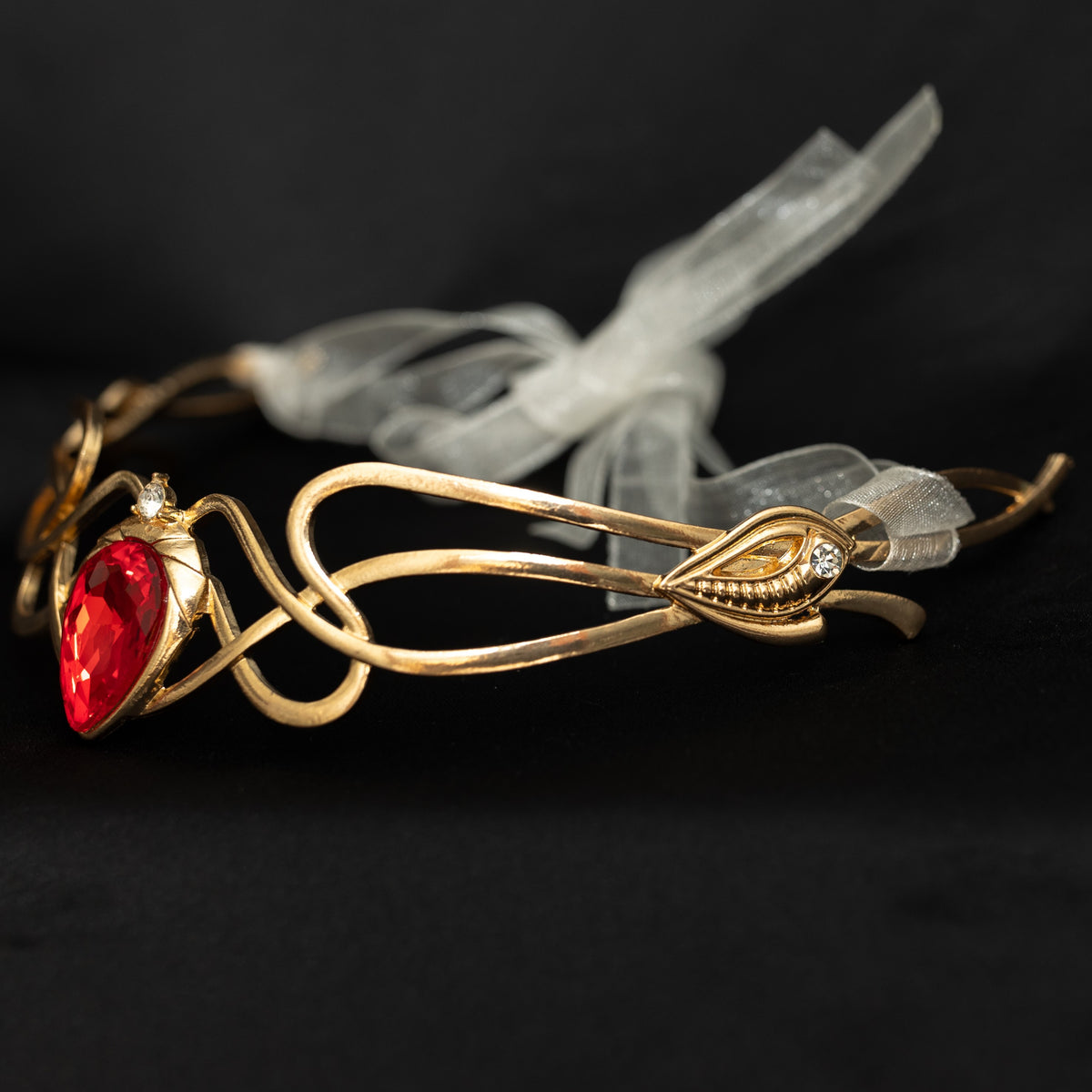 Gold bracelet with a red gemstone on a dark background