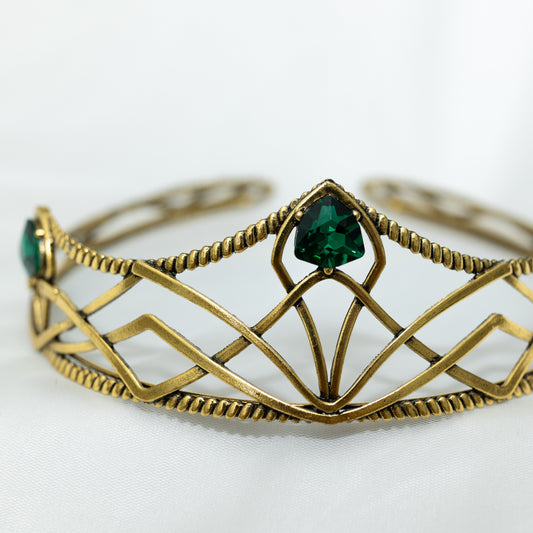 emerald crystal three point green gem on gold crown with curving designs and detailed edges - Close Up Center Side