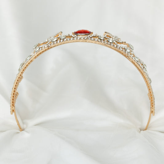 A sparkling tiara with a central red crystal, surrounded by clear crystals on a gold-colored base, designed to resemble antlers, set against a white background.-Bottom view