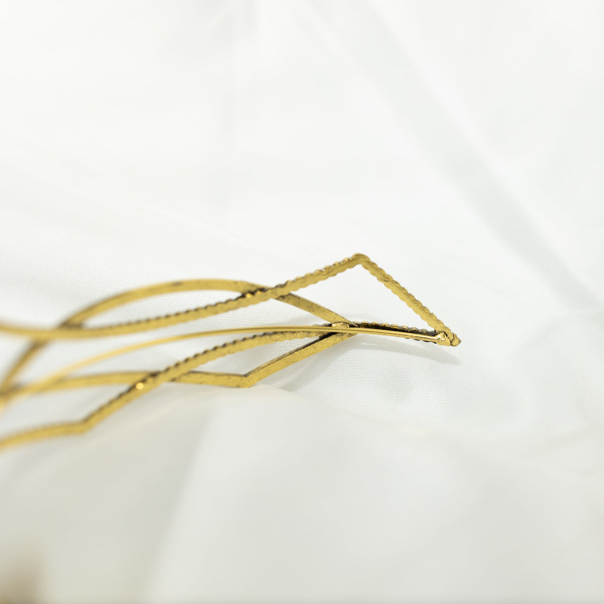 Gold geometric hair clip on a white background
