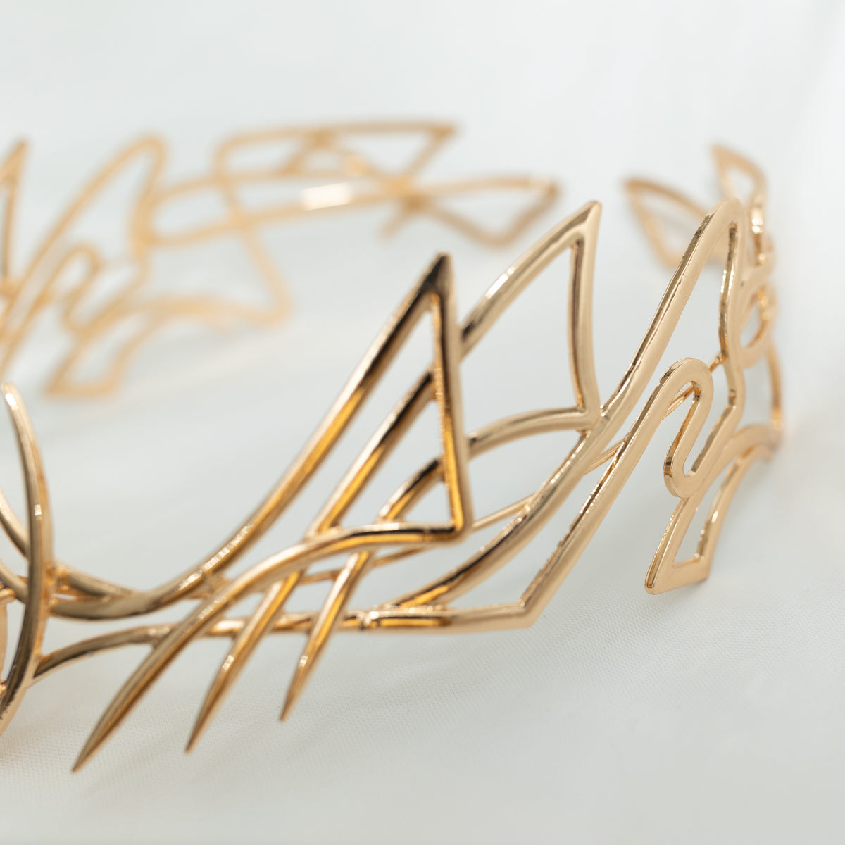 Gold bracelet with intricate design on a light background