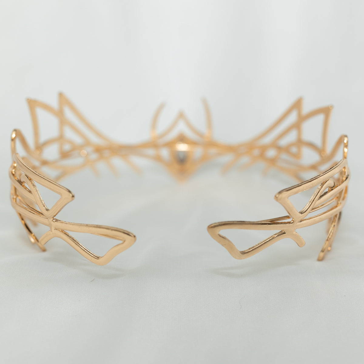 Gold geometric cuff bracelet on a light gray background
