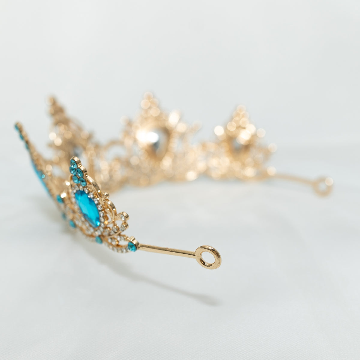 Gold bracelet with turquoise stones on a light gray background