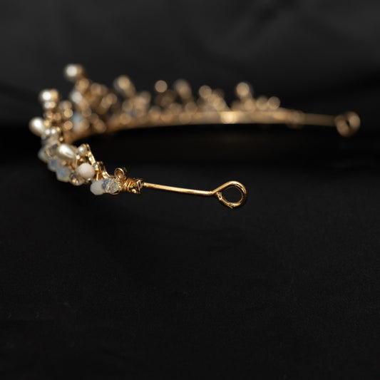 A gold-colored metal tiara with intricate designs and embellishments, displayed against a dark background - bea and pearl highlights attached with wire throughout