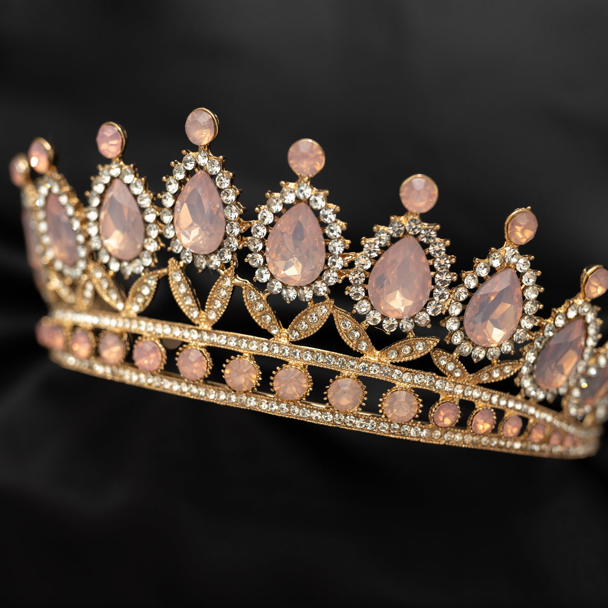 Gold tiara with pink stones on a black background