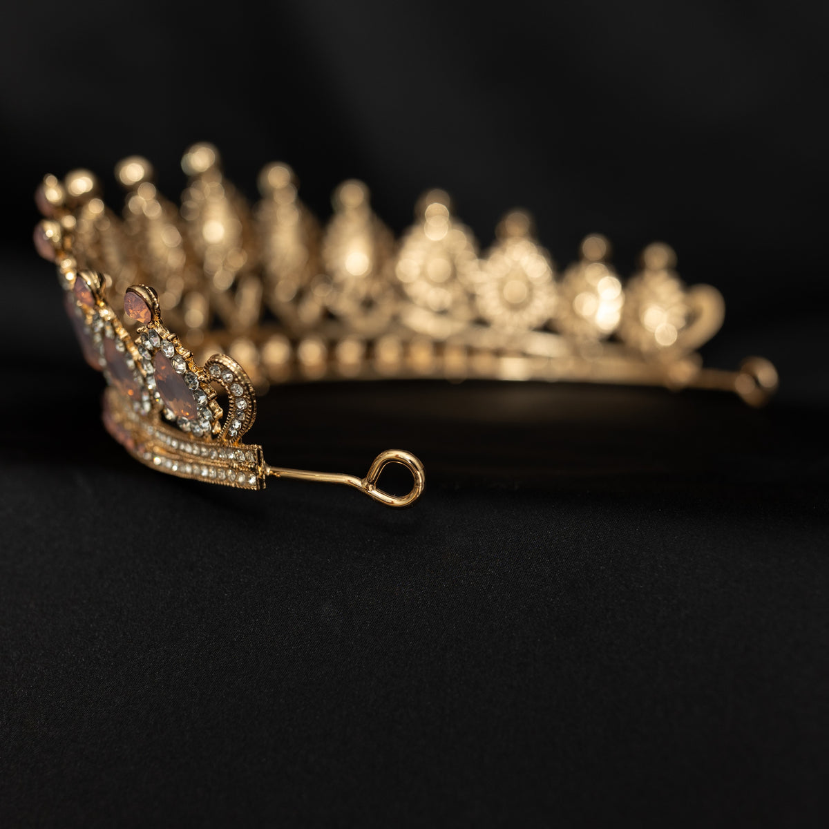 Gold tiara with intricate design on a black background