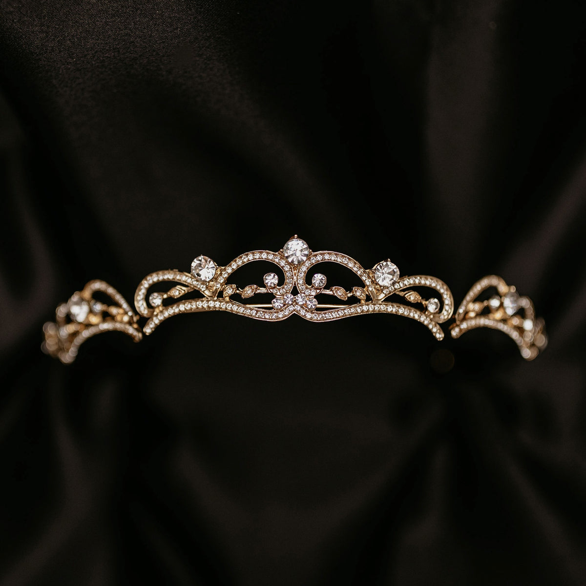 Elegant minimalist gold tiara with delicate crystal accents and classic curved design - Front View