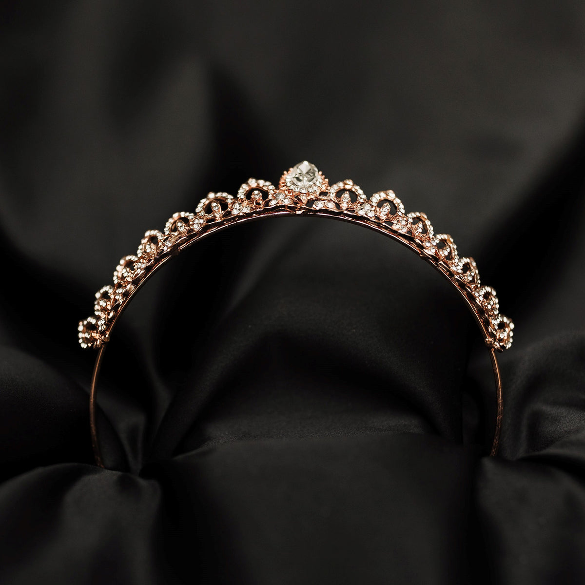 Rose gold tiara with diamonds on a black background