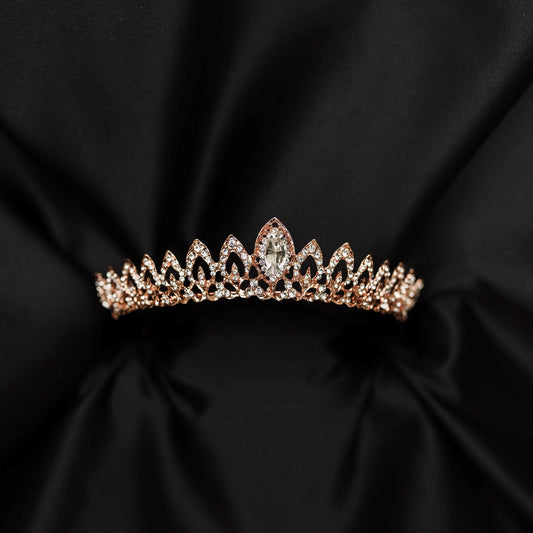 Rose gold tiara with clear gemstones on a black satin background