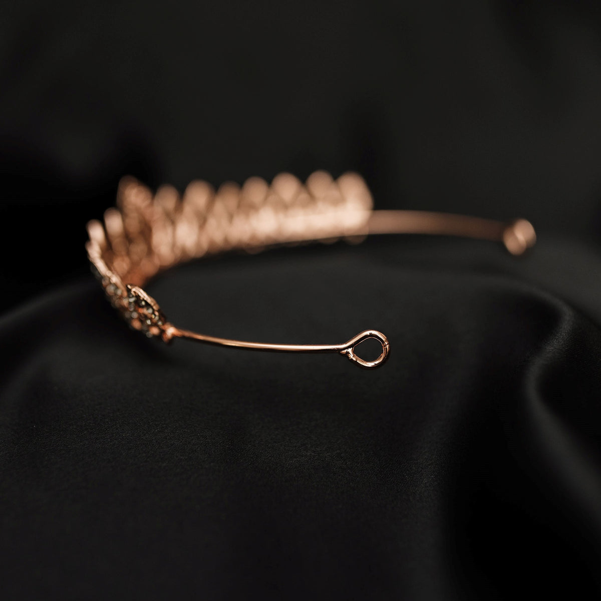 Rose gold headband with decorative elements on a black background