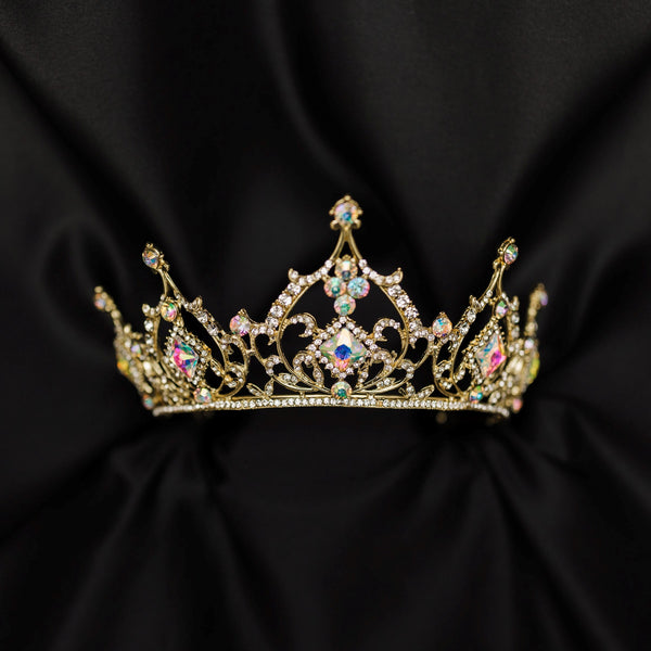 Gold tiara with opal glass crystal gemstones on a black fabric background_ Front