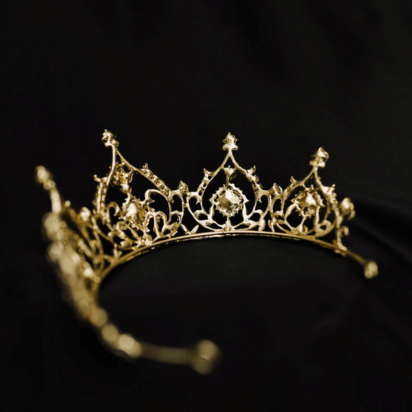 Gold tiara with opal glass crystal gemstones on a black fabric background_ Back
