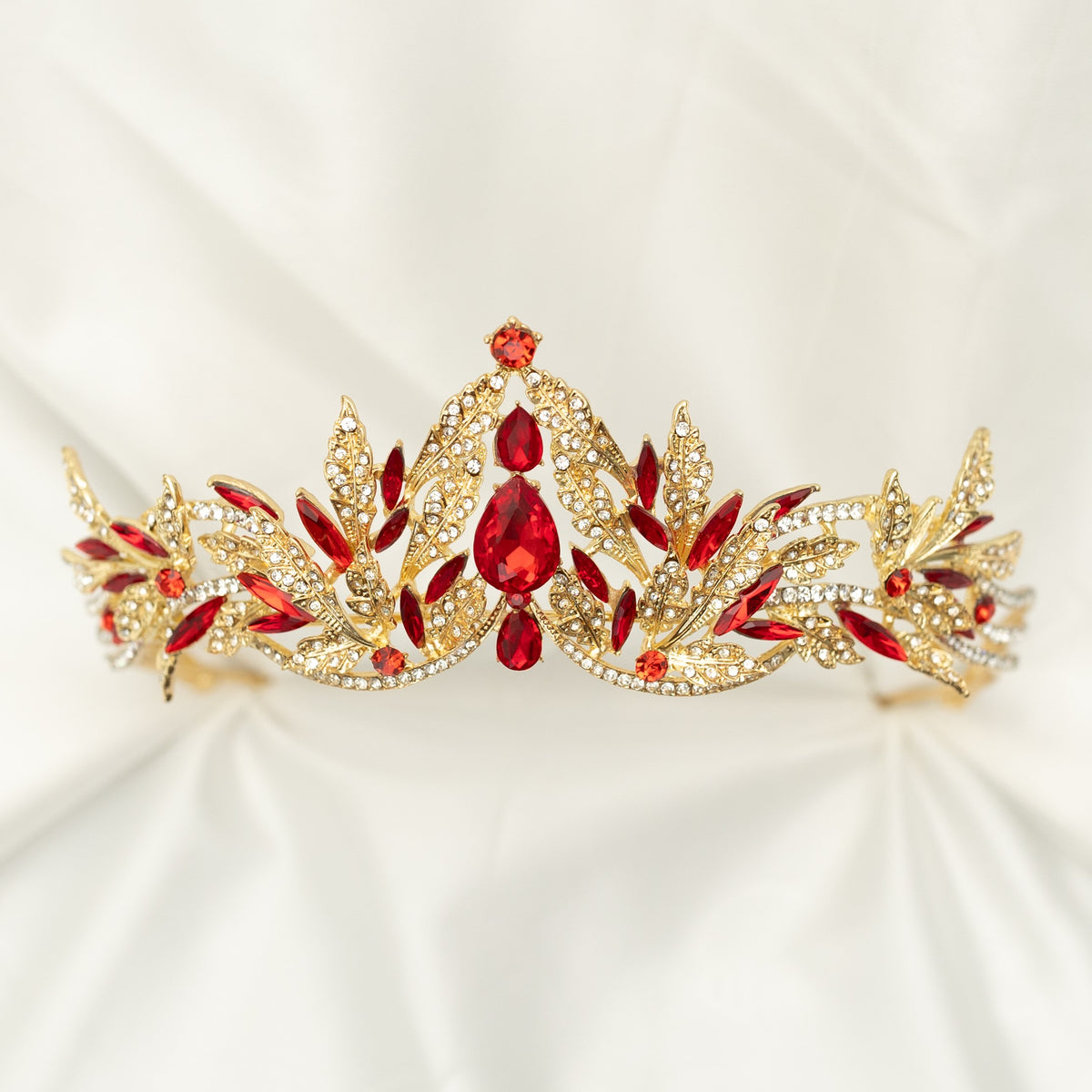 A golden tiara with red crystal embellishments and leaf detailing, displayed against a white background. - Front View 