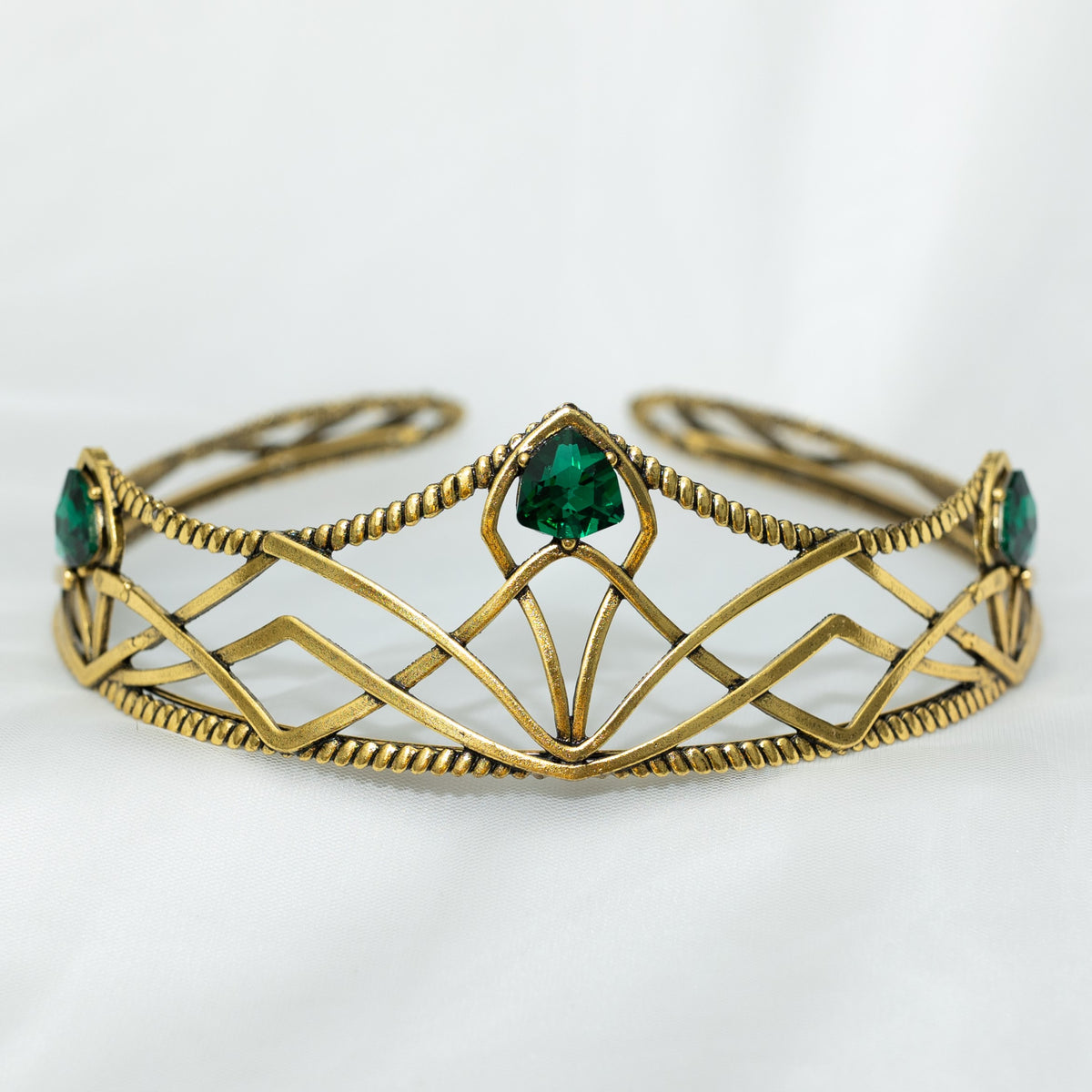 emerald crystal three point green gem on gold crown with curving designs and detailed edges - Front View 