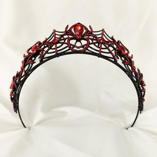 A sparkling tiara featuring a black spider web design with red crystals and a central red crystal, displayed on a white background. - bottom view