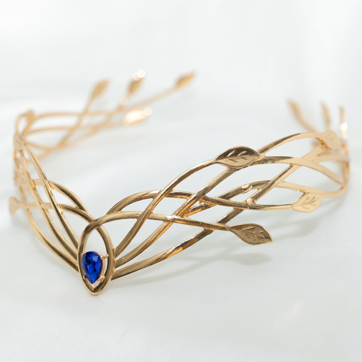 Gold circlet with blue gemstone on a white background