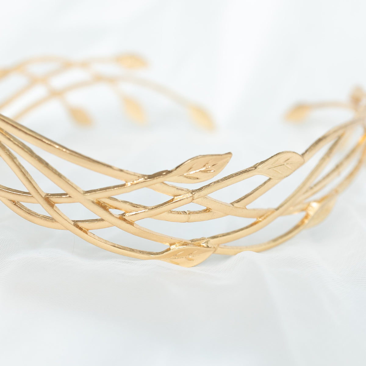 Gold bracelet with leaf designs on a white background