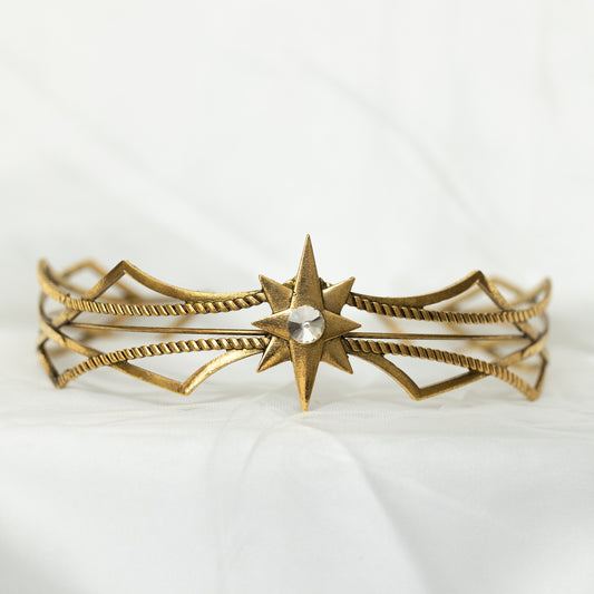 Gold bracelet with star design on a white background
