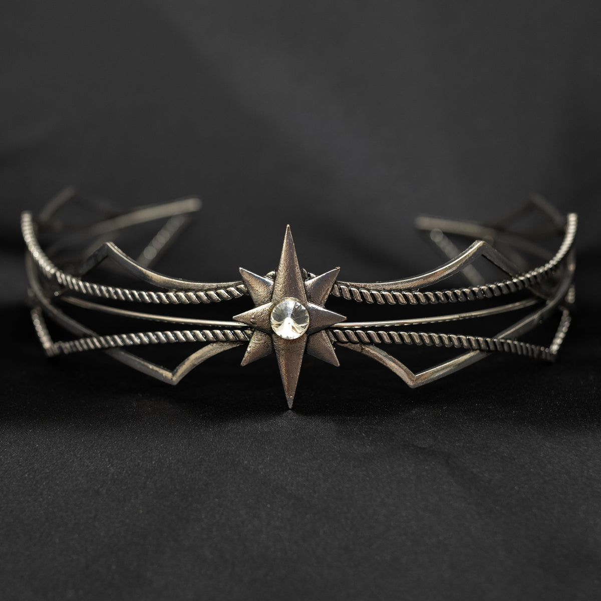 Silver star-shaped headpiece on a black background w/ central clear crystal - Front View 