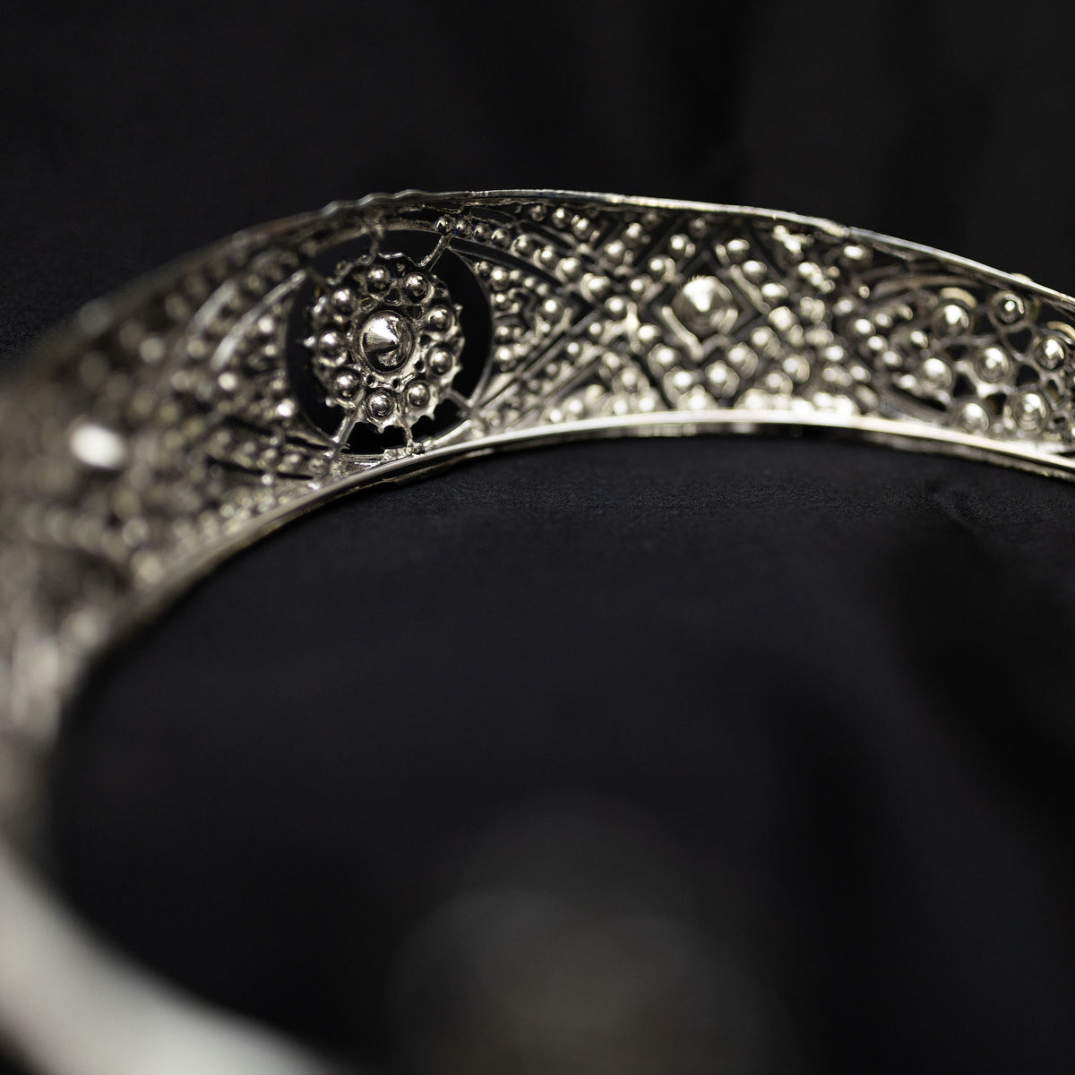A silver-colored metal tiara with clear crystals set around the circumference, featuring a central decorative front -  Back View 