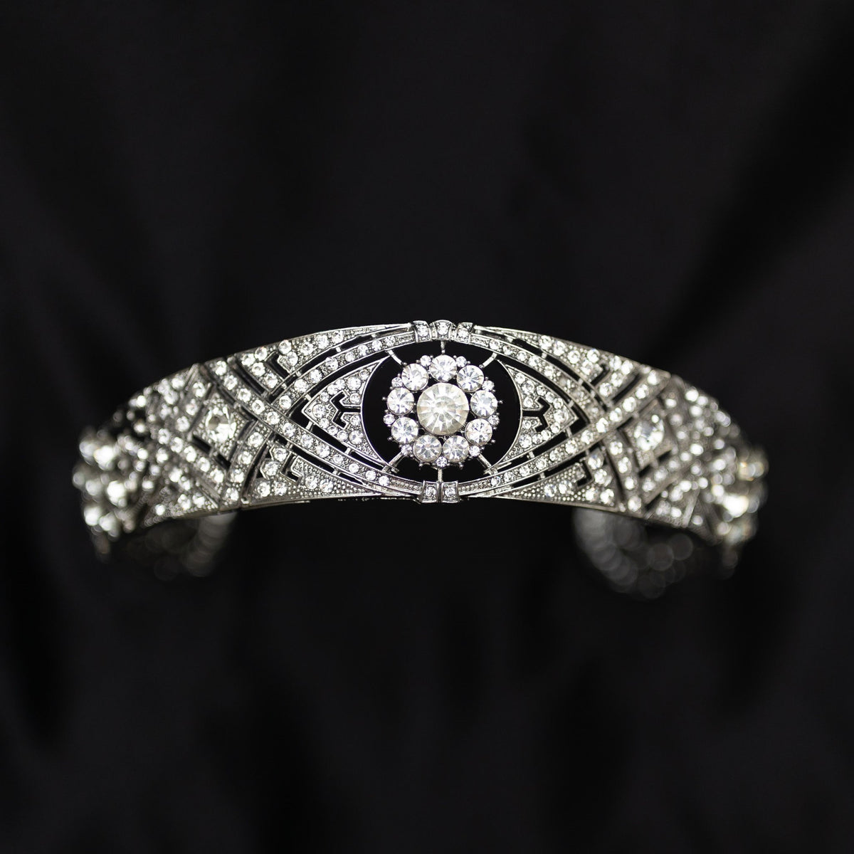 A silver-colored metal tiara with clear crystals set around the circumference, featuring a central decorative front - Front View 