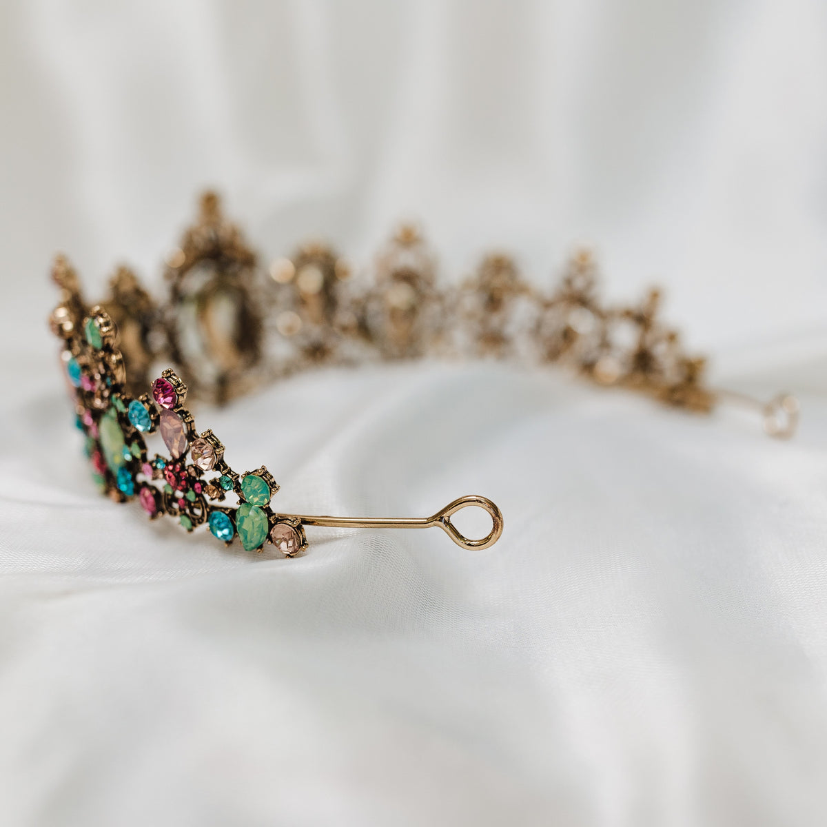 Tiara with multi color tear drop stones, light blue, light ping, teal, with small round stones throughout set in antique gold color metal - Looped End View 