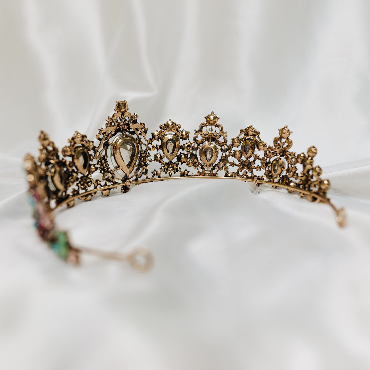 Tiara with multi color tear drop stones, light blue, light ping, teal, with small round stones throughout set in antique gold color metal - Back View 