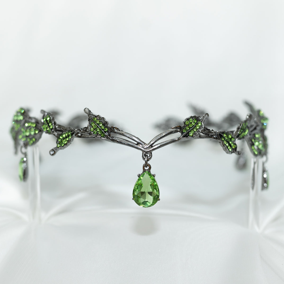 An elegant circlet crown featuring green drop jewels and leaf details, with an antique silver finish.