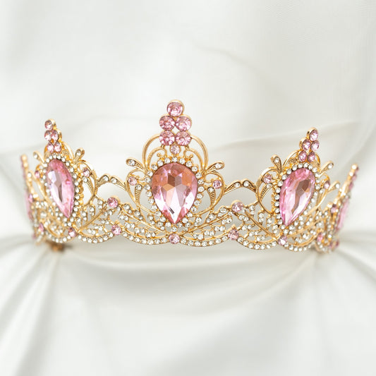 Gold tiara with pink gemstones on a white background