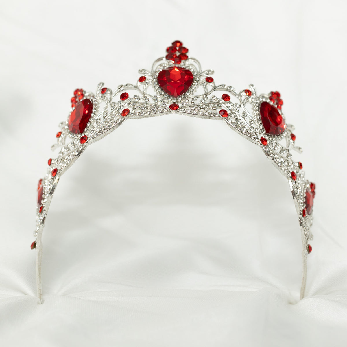 Silver tiara with red gemstones on a white background