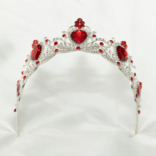 Silver tiara with red gemstones on a white background
