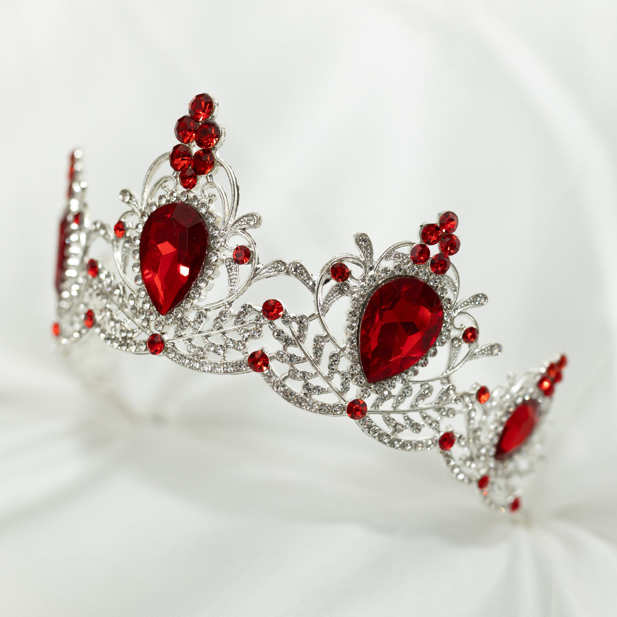 Silver tiara with red gemstones on a white background