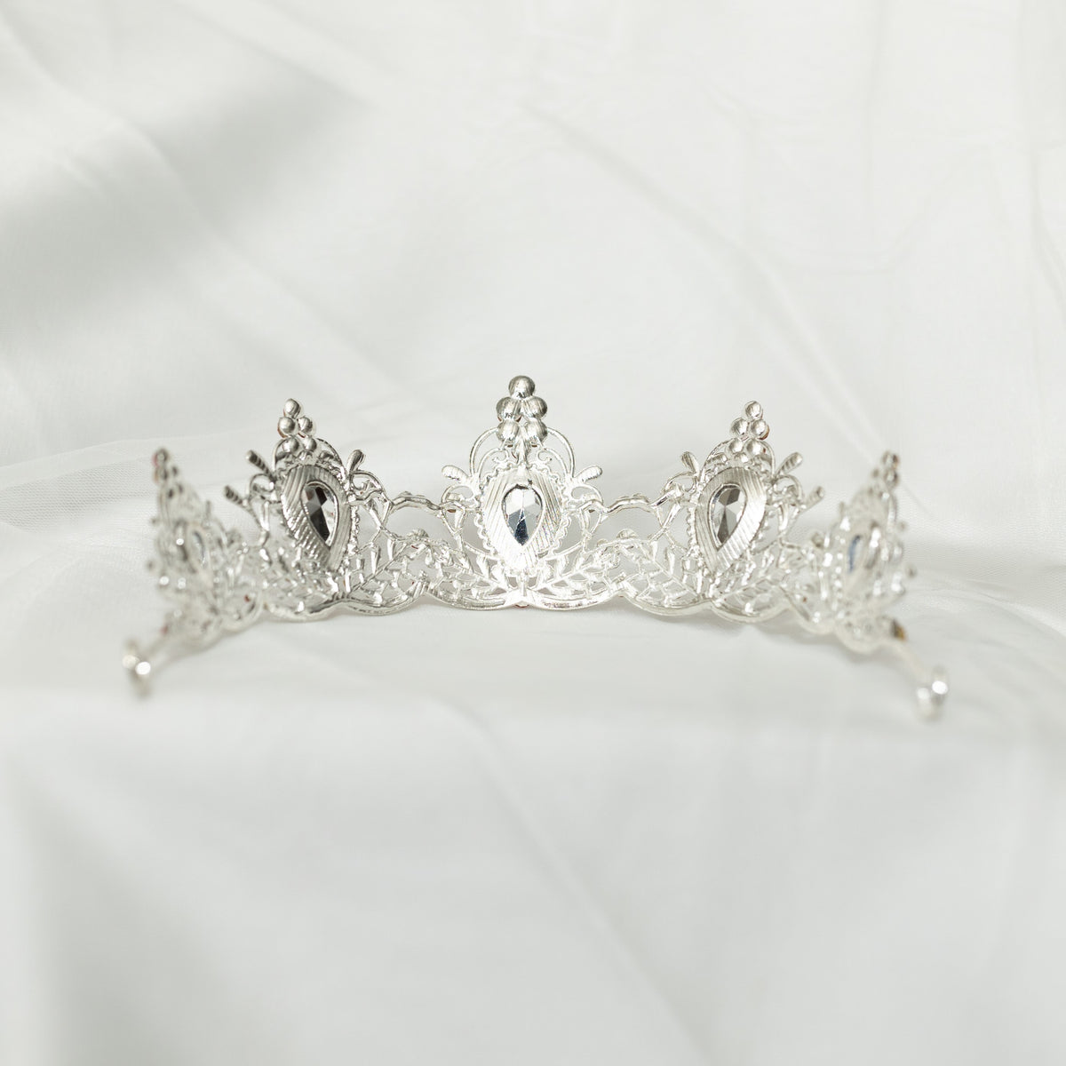 Silver tiara on a white satin background