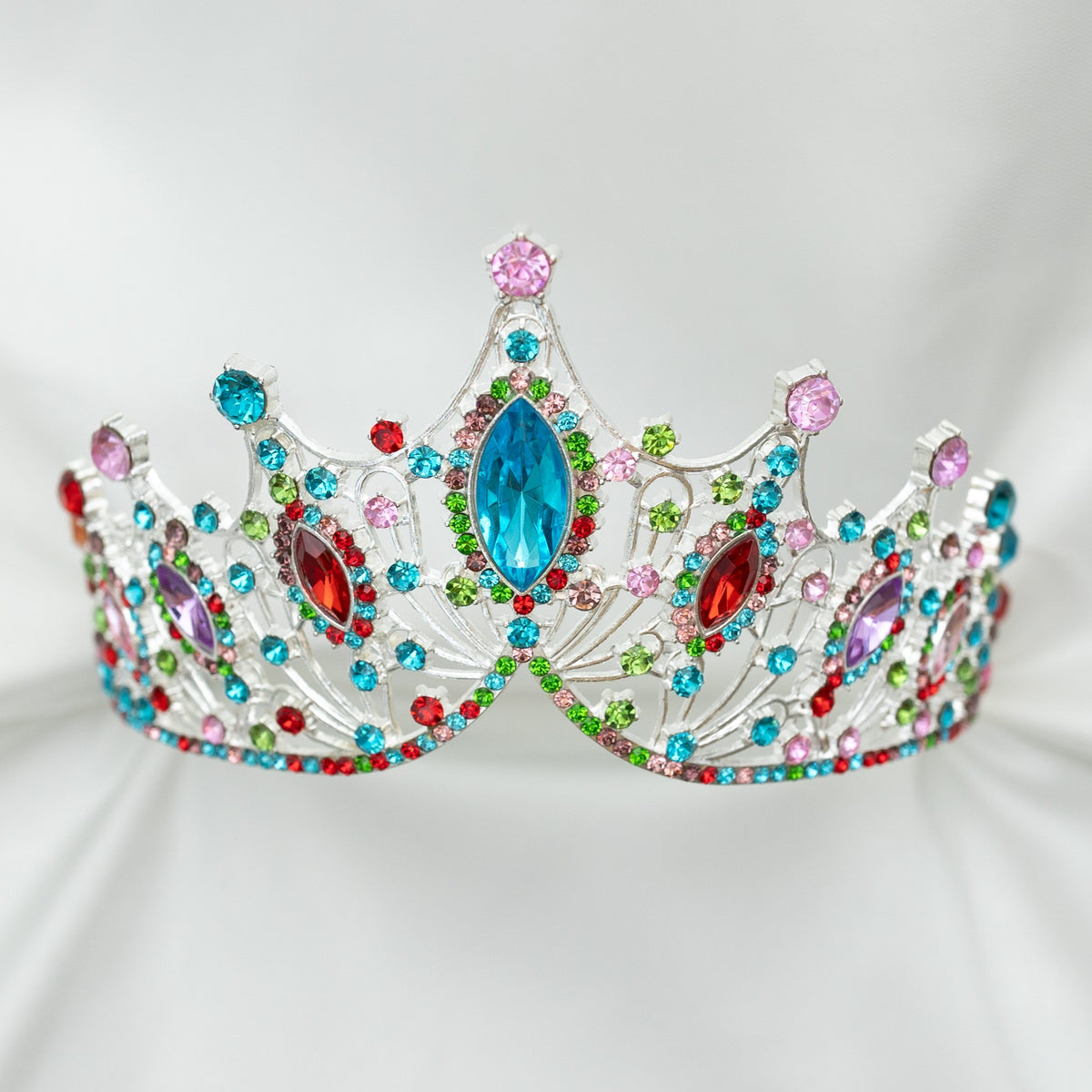 Colorful tiara with gemstones on a light gray background