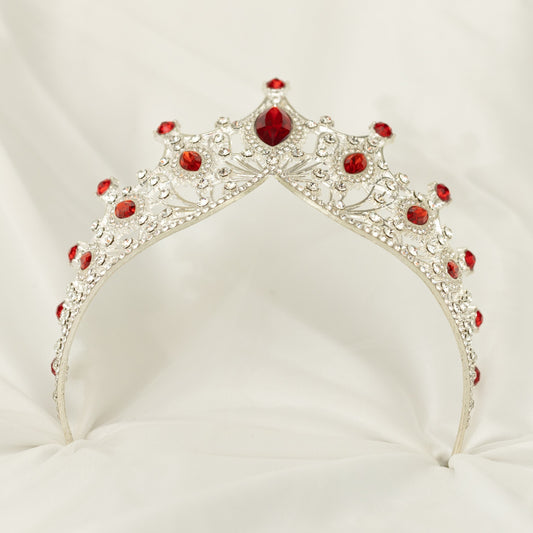 Silver tiara with red gemstones on a white background