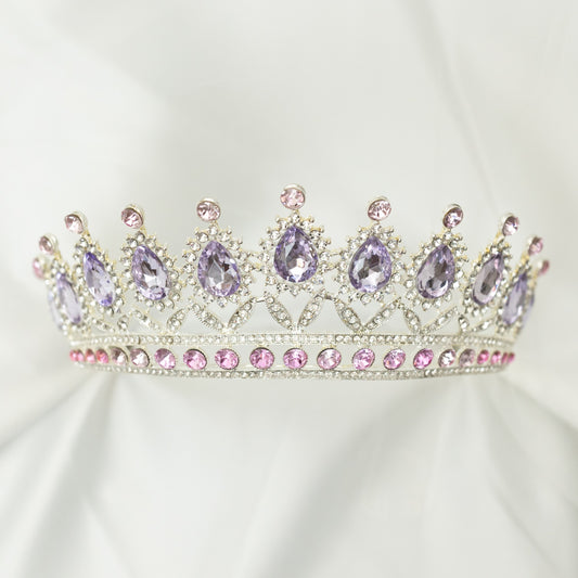 Elegant tiara with purple and pink gemstones on a white background