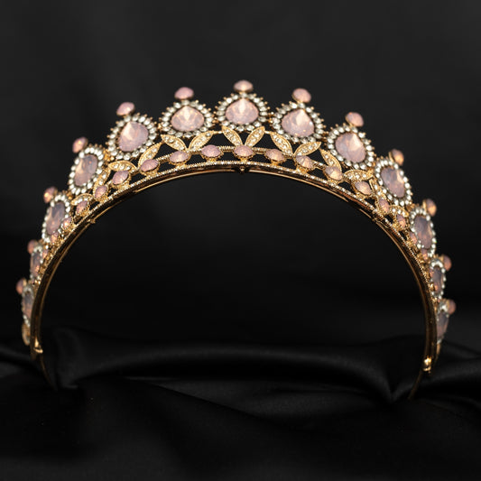 Gold tiara with pink stones on a black background