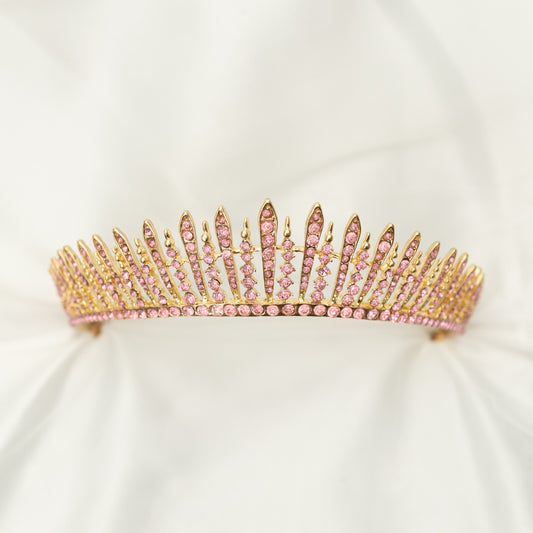 A pink and gold tiara with a spire design, featuring clear crystals. Front view