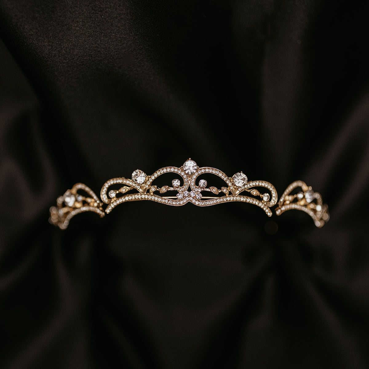 Elegant minimalist gold tiara with delicate crystal accents and classic curved design - Front View