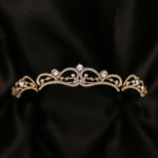 Elegant minimalist gold tiara with delicate crystal accents and classic curved design - Front View
