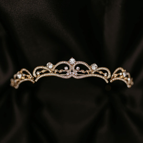 Elegant minimalist gold tiara with delicate crystal accents and classic curved design - Front View
