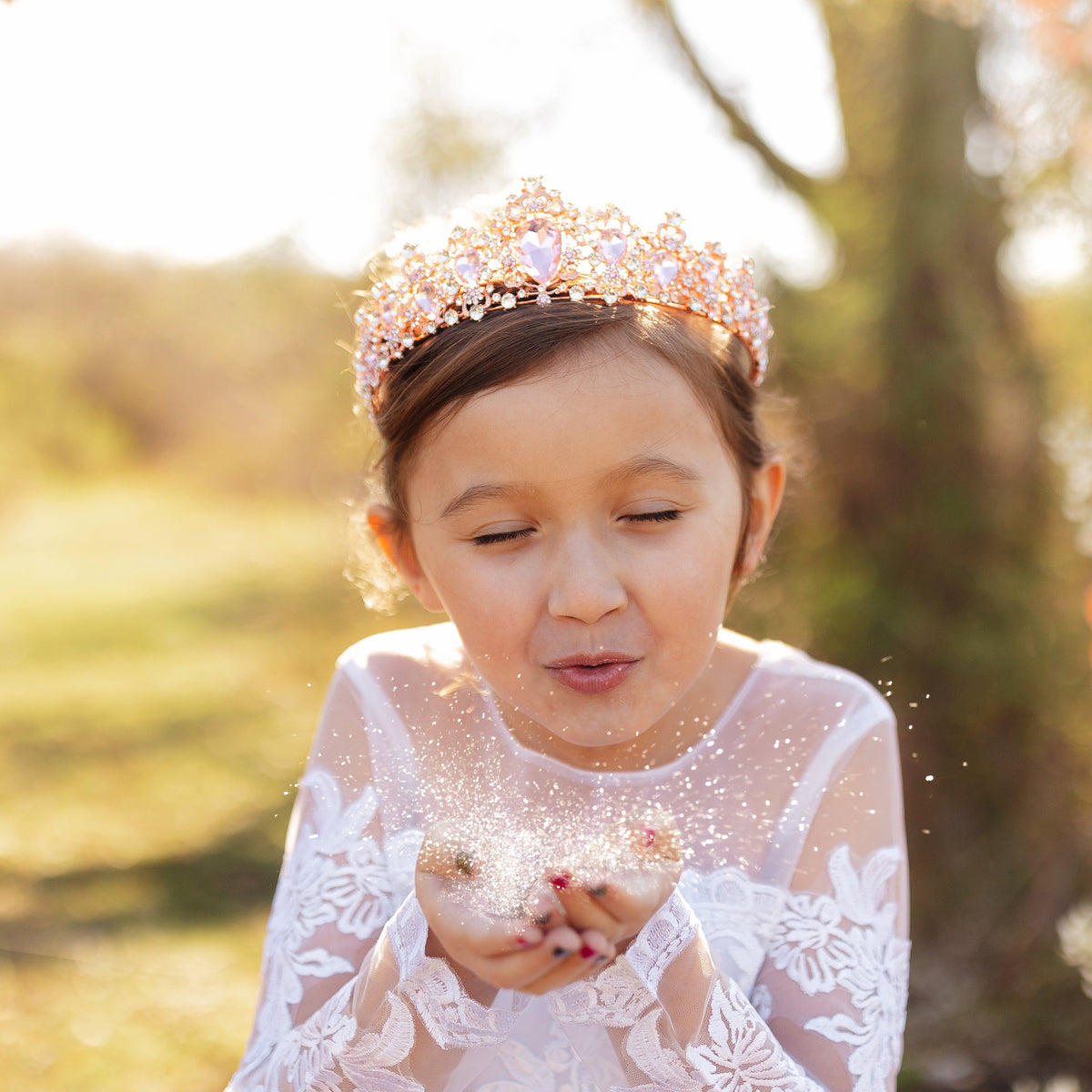 Modeled Michelle's Tiara in Pink - Little girl wearing large tiara with pink tear drop stones with small round stones throughout set in rose gold color metal 