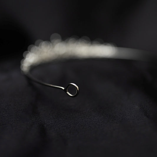 Silver tiara on black background - small crystals with silver metal details in triangular shape - Looped end view 