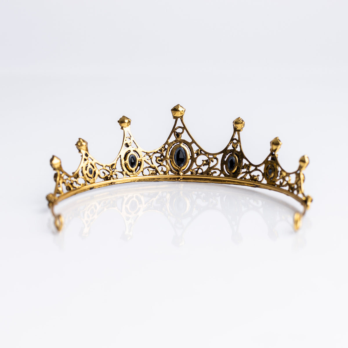 A baroque-style tiara with black colored crystals set in a yellow gold color setting, with loops on each end for securing to hair - Rear View 